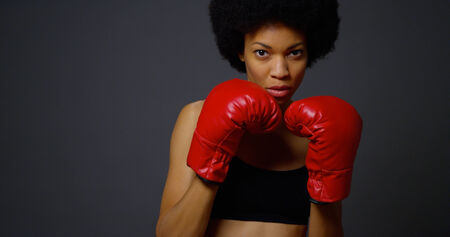 Black woman boxer punching towards cameraの写真素材