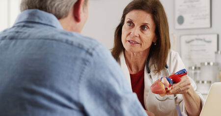 Doctor talking to elderly patient about heart
