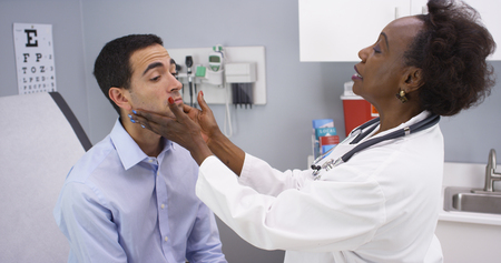 Young latino male patient having routine health checkupの写真素材