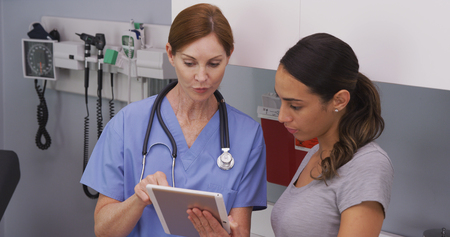 Close up of nurse explaining to young hispanic patient her health condition