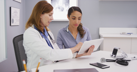 Professional medical physician and patient looking at tablet portable device