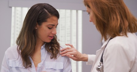 Close up of charming hispanic patient meeting with doctor about shoulder injuryの写真素材