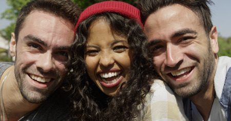 Closeup of three young multiracial friends enjoying the sun