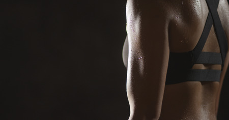 Active Chinese woman lifting dumbbells weights and sweatingの写真素材