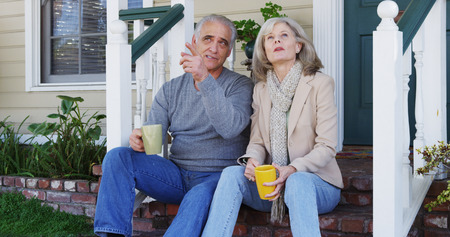 Senior couple sitting on porch talking