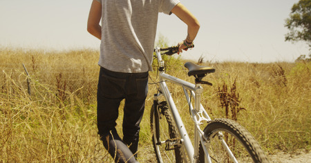 Hispanic man walking down trail with bike