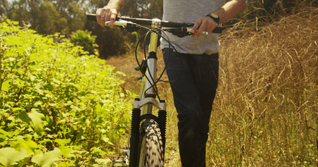 Mexican man walking down trail with bike
