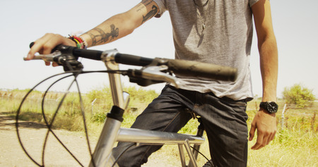 Sexy Mexican man sitting on bike in the countryside