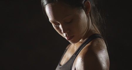 Active Asian woman lifting dumbbells weights and sweatingの写真素材