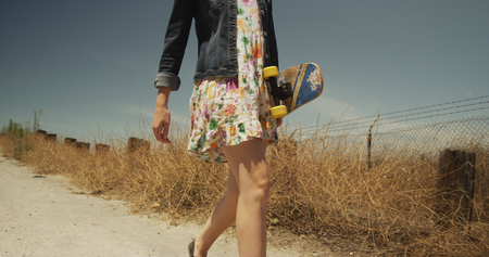 Cute young white girl walking with skateboardの写真素材