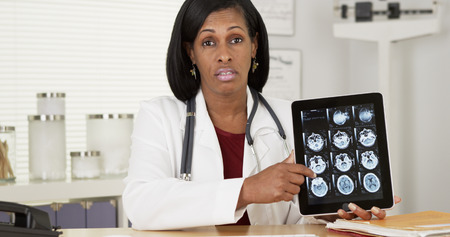 Female doctor holding tablet showing x-rays