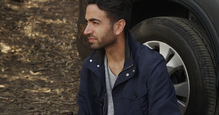 Attractive Hispanic man waiting for road assitanceの写真素材