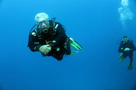 Two divers swimming in the blueの写真素材