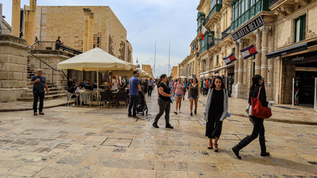 Republic Street, Valletta, Malta. In the background can be seen the Parliament building. Here shops, cafes and pedestrians an be seen.のeditorial素材