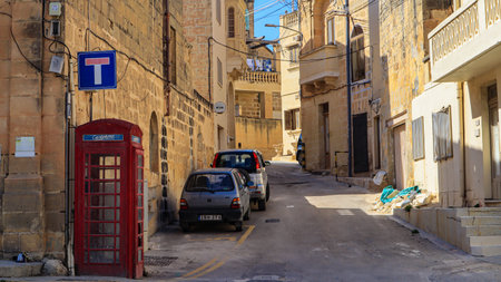 A dusty street and phone booth in Kercem, on the Mediterranean island of Gozo in the Maltese archipelago.のeditorial素材