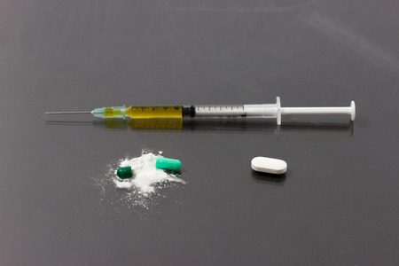 capsule tablet and syringe medicine on gray background