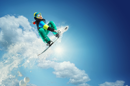 snowboarder jumping against blue skyの写真素材