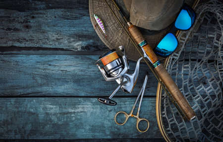 Fishing tackle on a wooden background. Fishing rod, reel, hat and other accessories.の写真素材