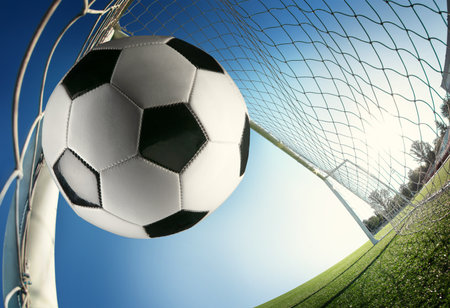 Soccer ball in the goal net on blue sky background. 3d renderingの写真素材