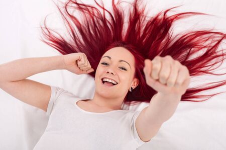 Young red haired woman happy cheersの写真素材