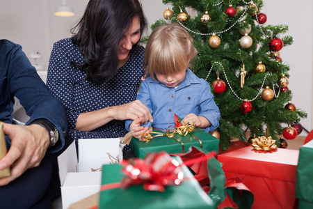 family unboxing christmas presents in front of christmas treeの写真素材