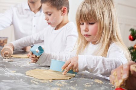 childs using christmas cookie moldsの写真素材