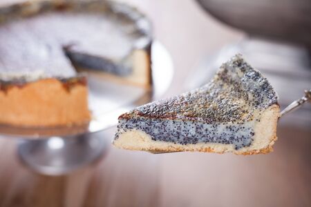a pice of poppy seed cake with the gateau in backgroundの写真素材