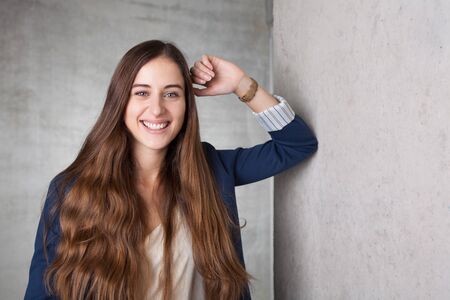 woman leans at concrete wallの写真素材