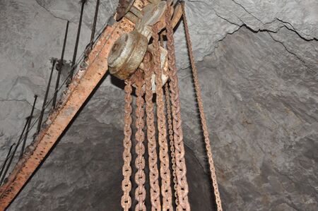 Rusty chains hanging from ceiling inside mineの写真素材