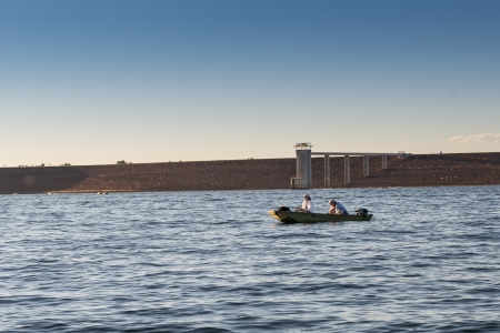 Couple fishing in a boat at sunsetの写真素材