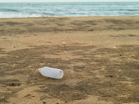 used plastic botttle on the beach left by touristの写真素材