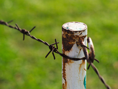 rusty metal barbed wires on old and decayed metal poleの写真素材