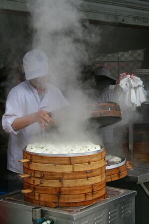 Shanghai, China - March 30, 2010 - A Chef lifting the lid on a bamboo steamer full of Pork Bunsのeditorial素材