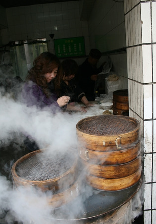 Xiani, China - March 31 2011 - A woman watching over a bamboo steamer in a street stall located in Xianのeditorial素材