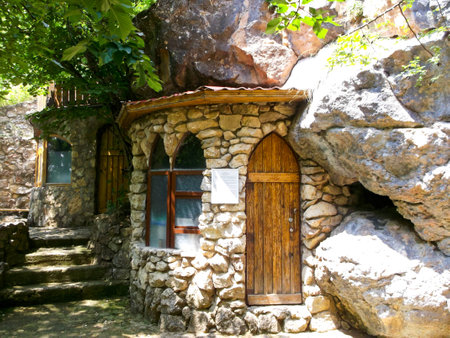 interesting building carved into the rock surrounded by greeneryの写真素材