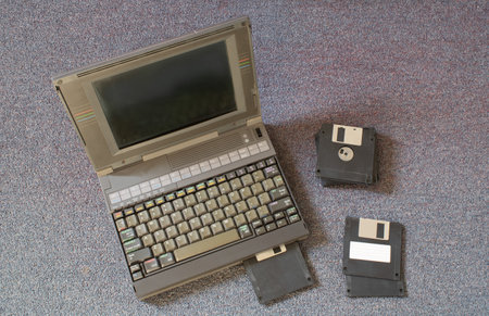 floppy disks and old laptop on a bedroom carpet