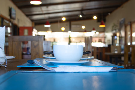 Coffee cup on table in coffee shop cafe, stock photo