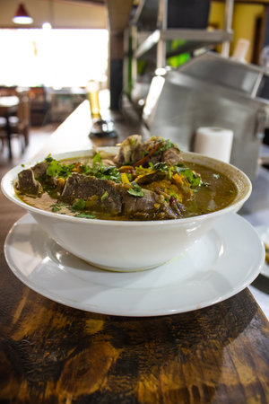 beef stewed with herbs and spices in a bowl on a wooden tableの写真素材