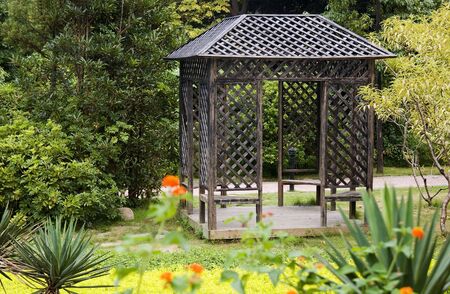 Summerhouse with perennial plants around in the parkの写真素材