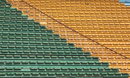 A field of empty white plastic stadium seats.