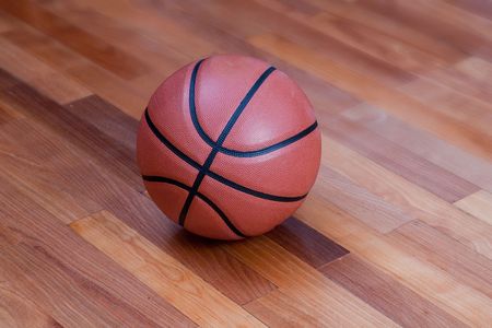 Basketball on the hardwood basketball floor in a stadiumの写真素材
