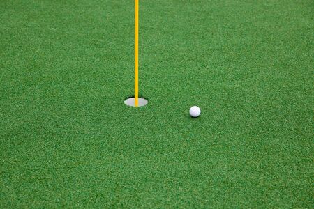 Hole with the flag and golf ball in a Driving Rangeの写真素材