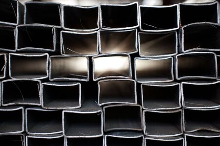 Stacked steel pipe with sunlight reflecting on the interior walls of central part.の写真素材