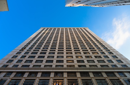 Looking up at the architecture of Skyscrapers with blue sky backgournd in a  modern city .