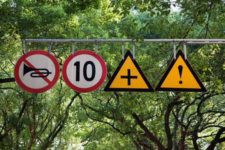 Four road signs with warning and speed limit on it in a city park Avenueの写真素材