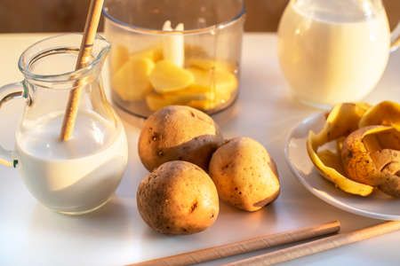 Vegan plant milk from potato in glass jar and potato tubers on the table. Concept of potato milk, vegan sustainable option, plant-based dairy. Substitute drink, healthy eating, diet, nutritionの写真素材