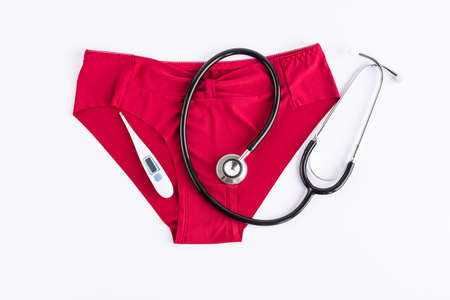 Womens underwear, stethoscope and thermometer. Concept of critical days, abdominal pain,...
