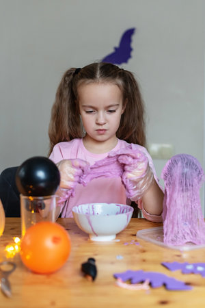 Caucasian female child engaging in Halloween craft activity at home, Cheesecloth Ghosts, Halloween craft.の写真素材