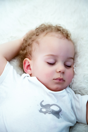 Sleeping baby boy. Close-up portrait of a beautiful sleeping baby boy in bed.  Newborn, childhood theme.の写真素材