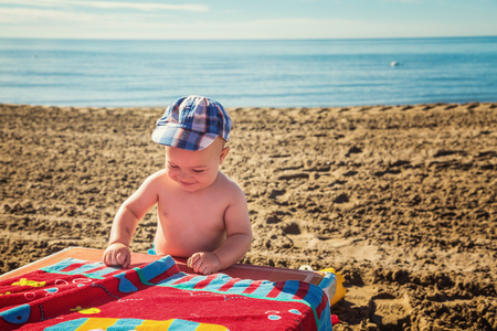 Cute baby boy playing on a beachの写真素材